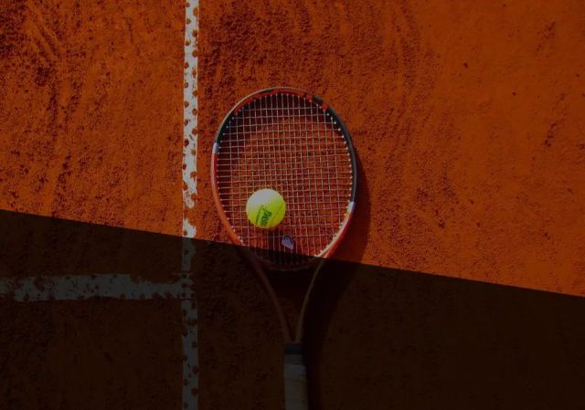 Tenisová raketa a míček na antuce